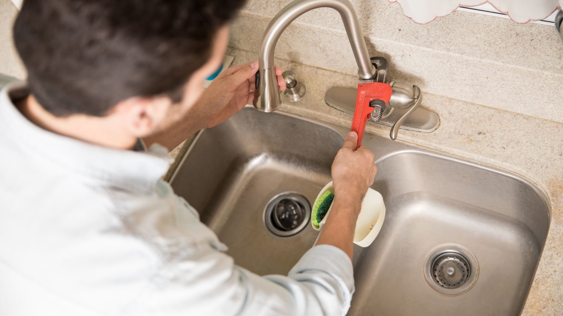 Licensed plumber repairing a pipe under a sink in Boca Raton, FL