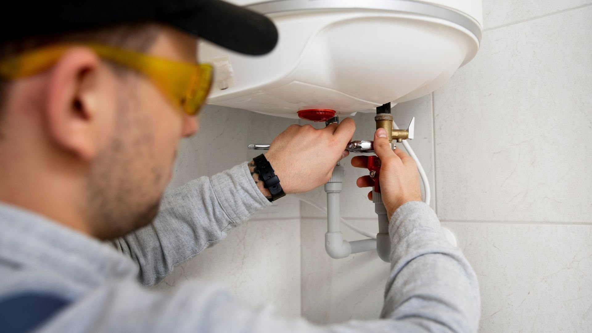 Plumber repairing a burst pipe during an emergency call