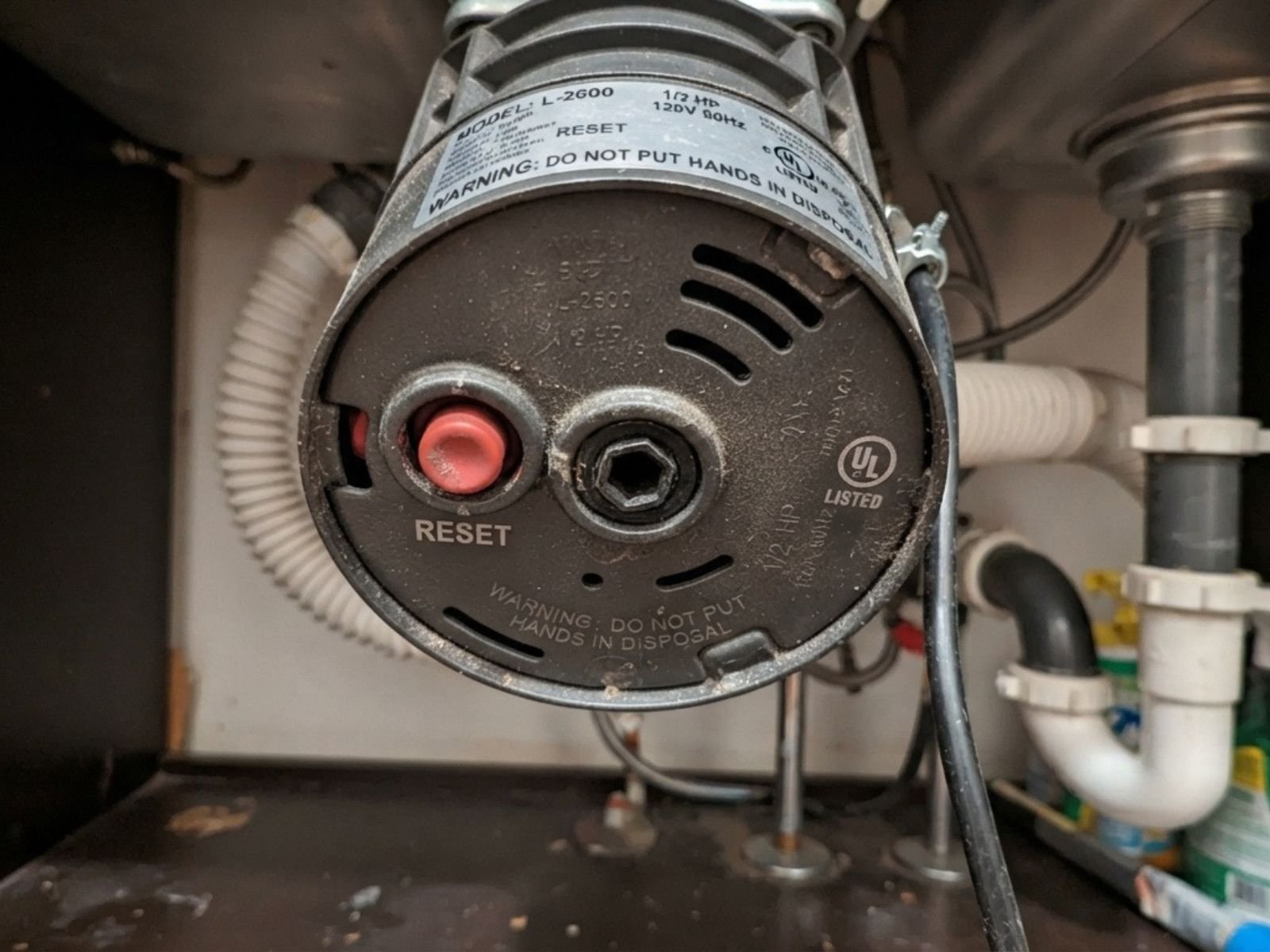 Plumber diagnosing a jammed garbage disposal